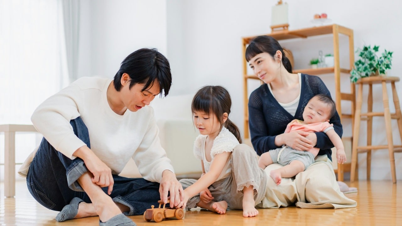 A couple playing with their kids indoors.