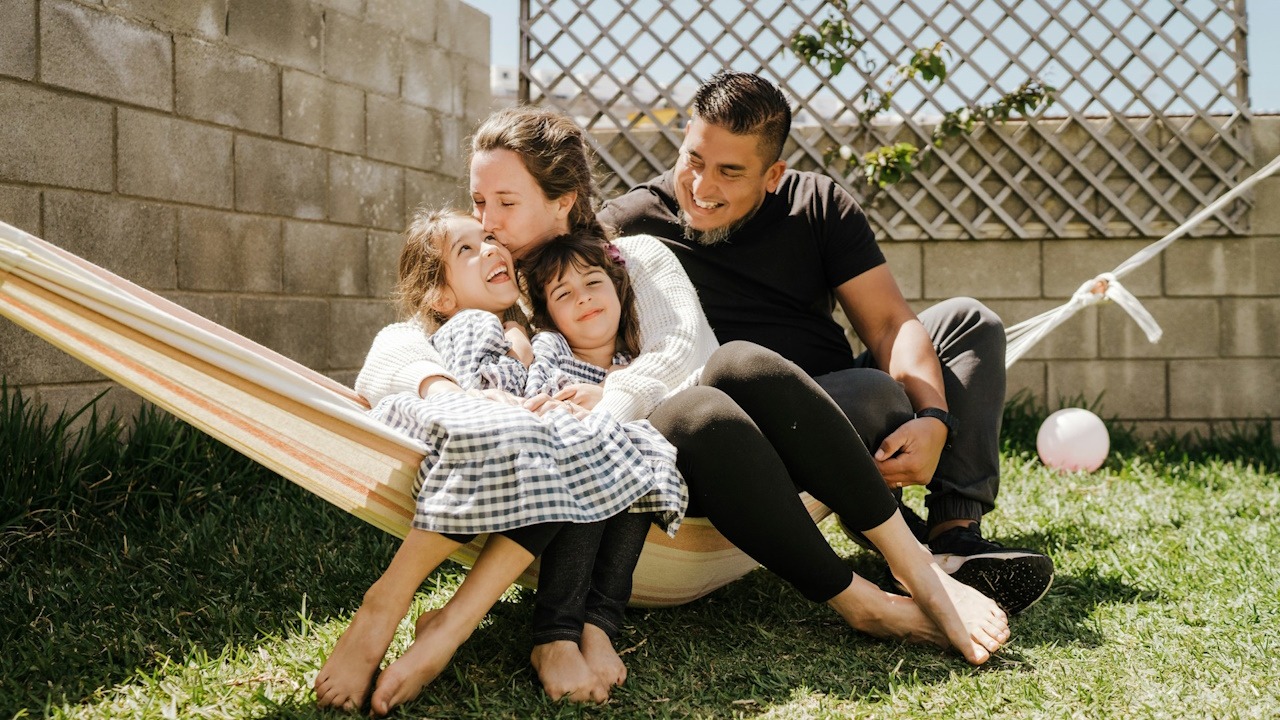 A family is sitting on the swing