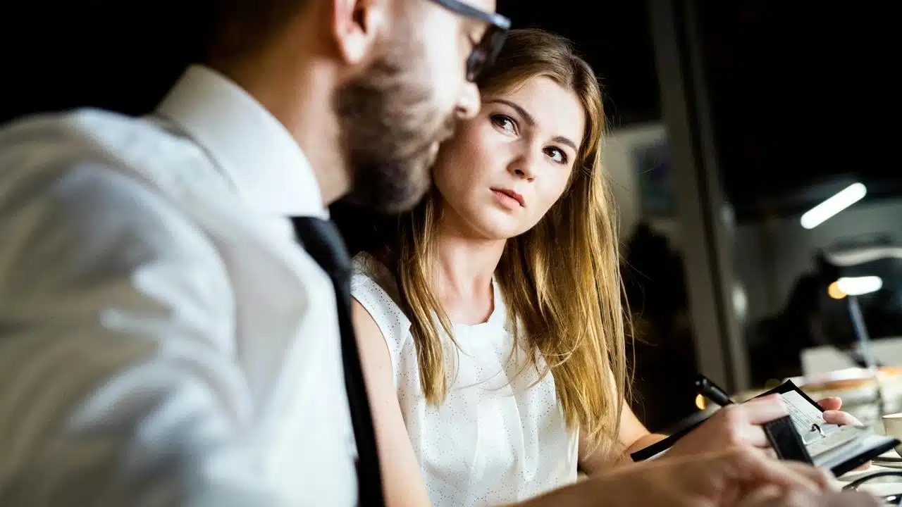 A woman giving a concerned look toward a man during a discussion.