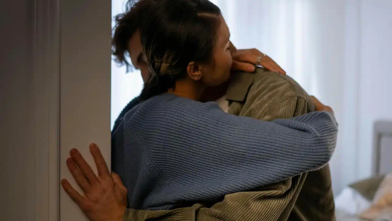 A couple embracing each other warmly indoors.