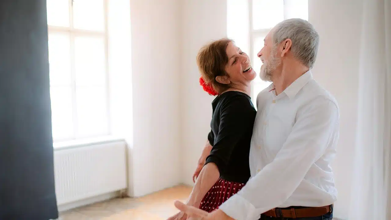 A couple laughing and dancing together.