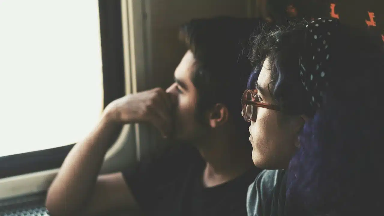 A thoughtful couple looking out of the window.