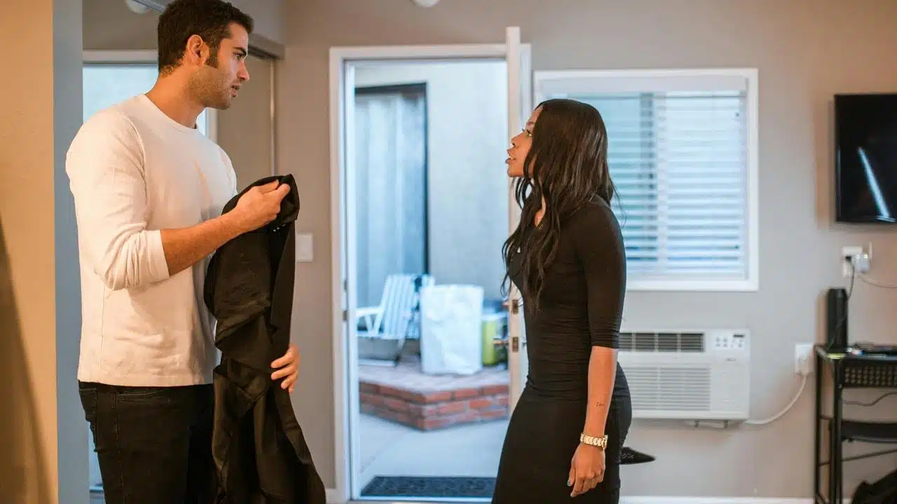 A man and a woman standing in a living room having a serious conversation.