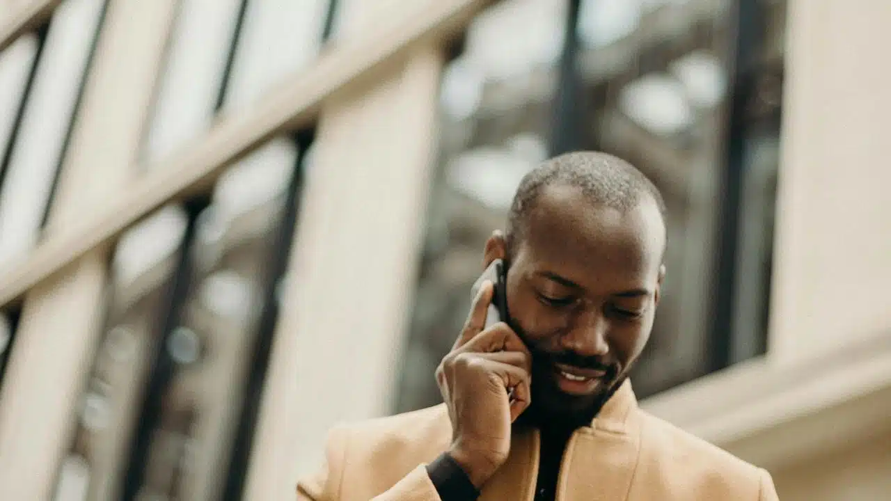 A man standing outside a building talking on his phone.