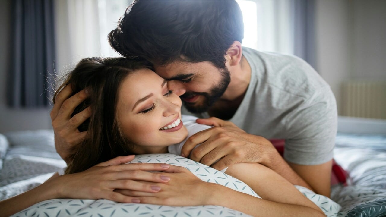 A couple cuddling in bed