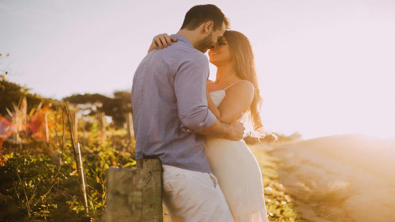A couple about to kiss at sunset