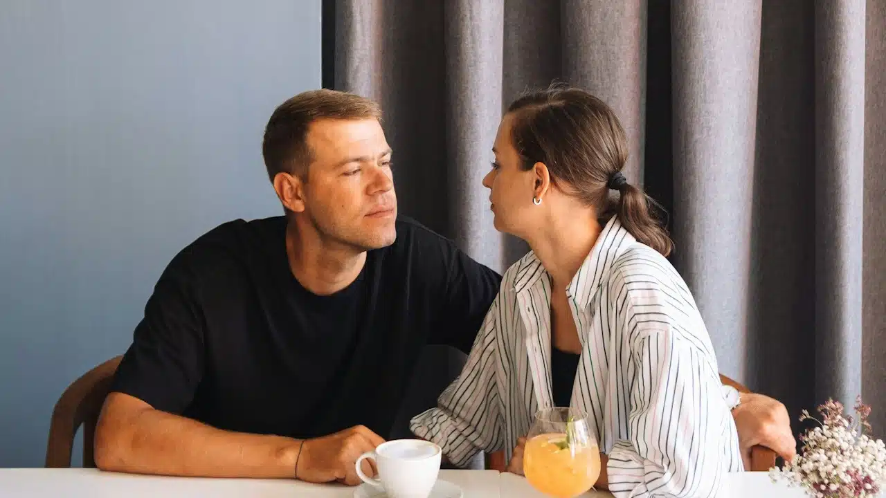 A Couple looking into each other's eyes while sitting at a table.