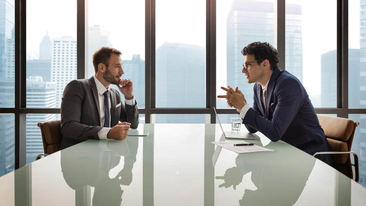 A business meeting between two men in a modern office.