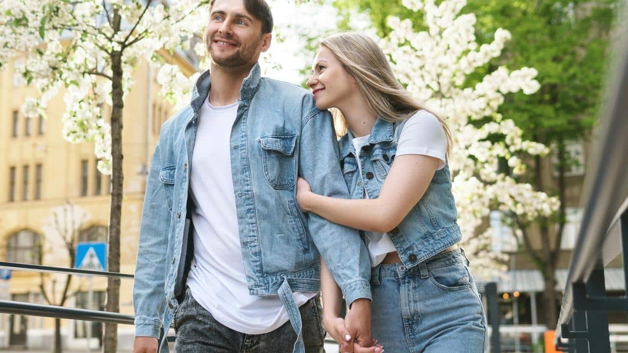 A happy couple walking hand in hand on a spring day.
