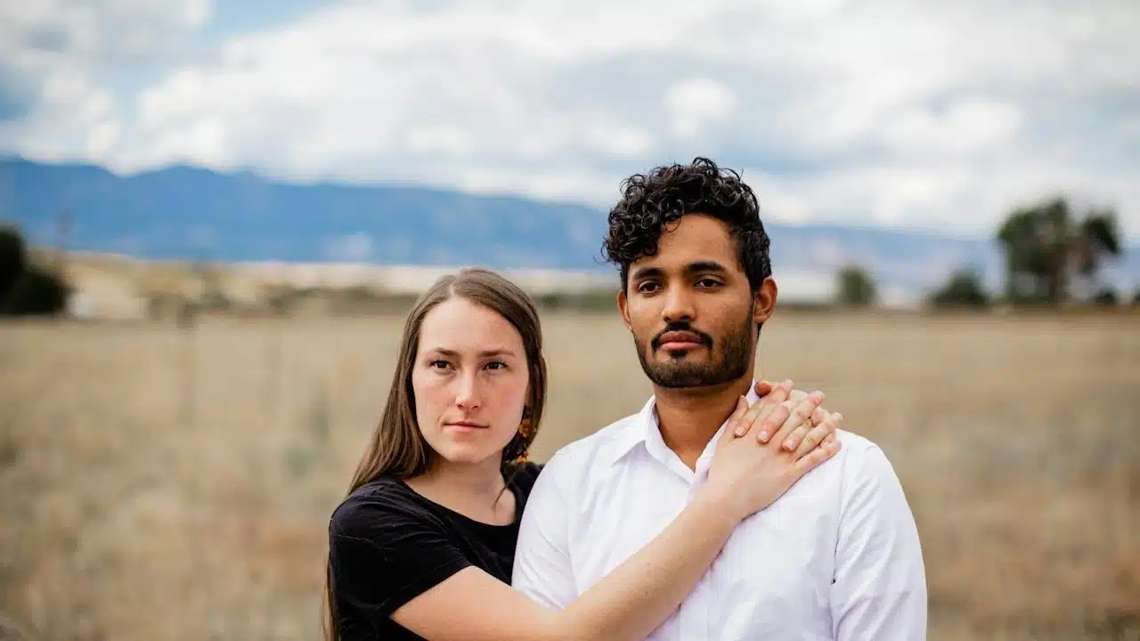 A man and a woman standing in a field.