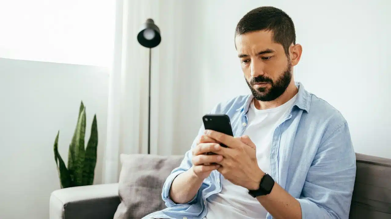 A man texting on a phone.