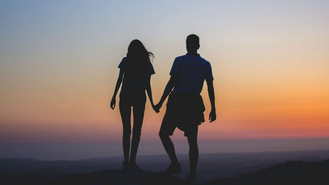 A picture of a couple holding hands.