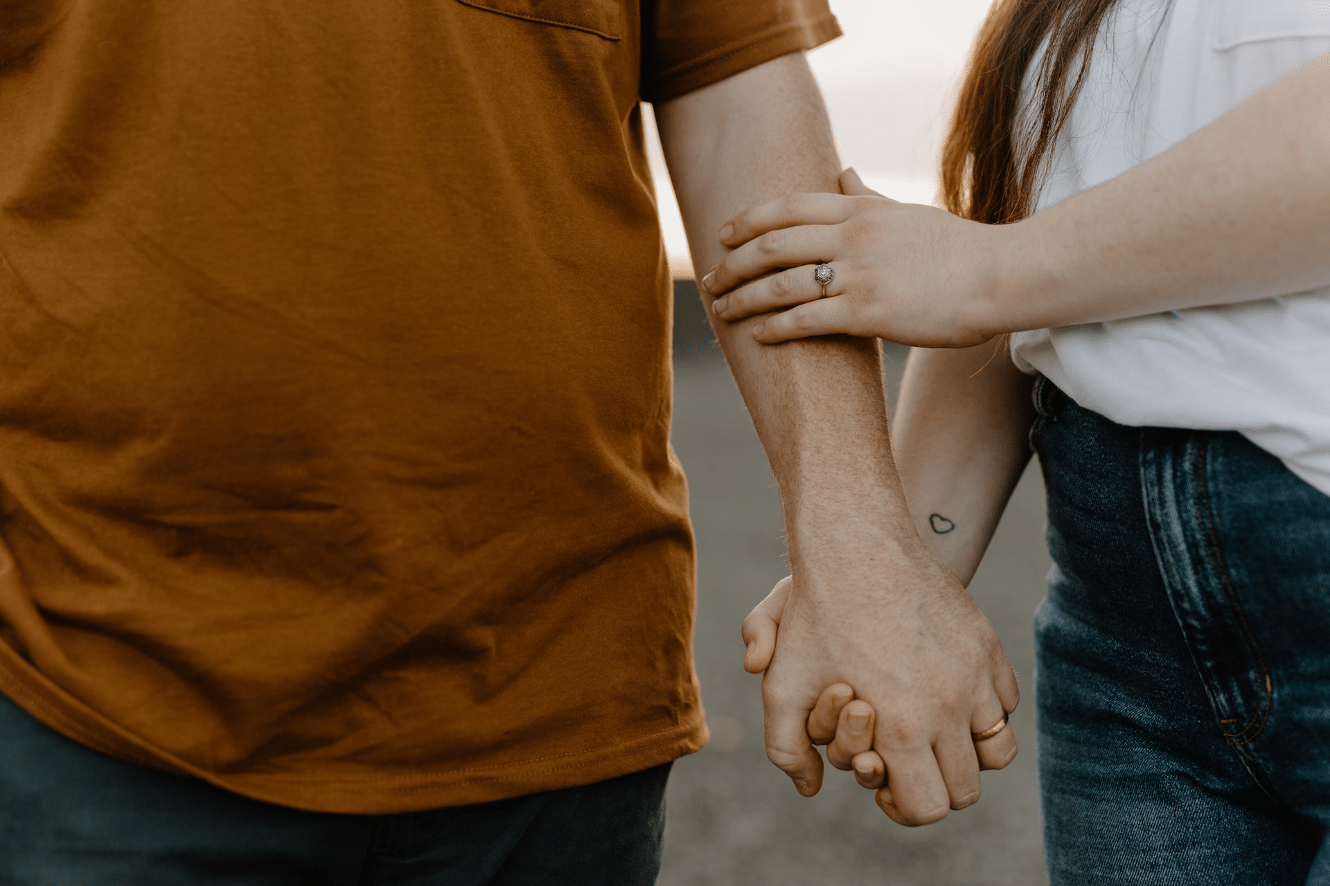 A close up of a couple holding their hands