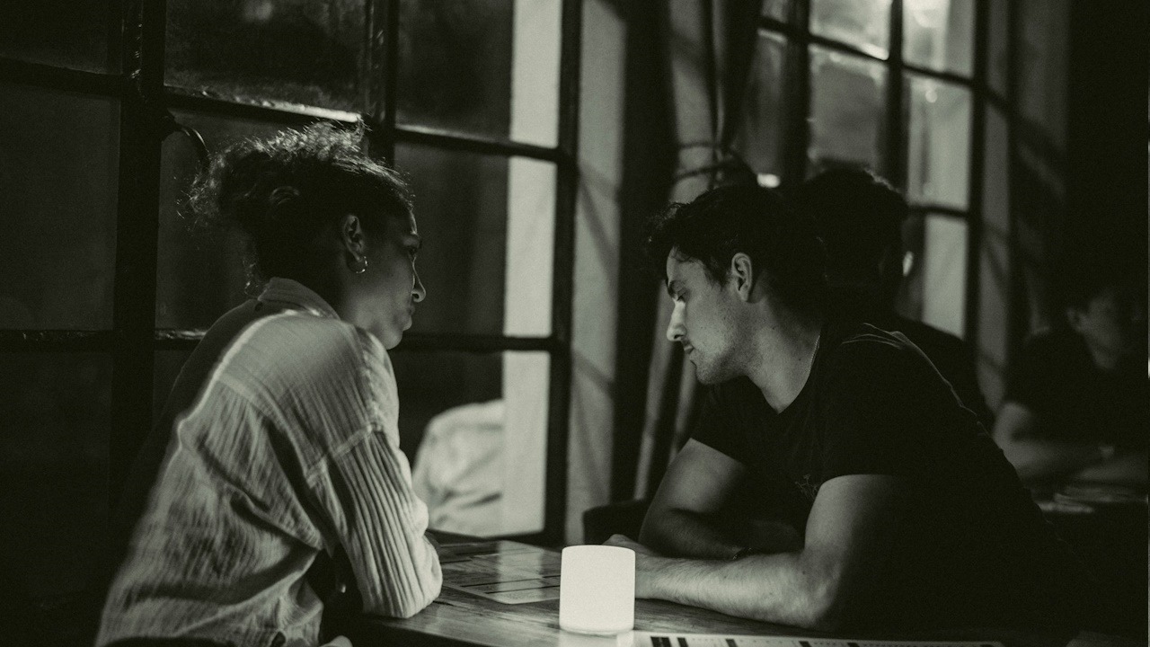 A depressed couple sitting at a table.