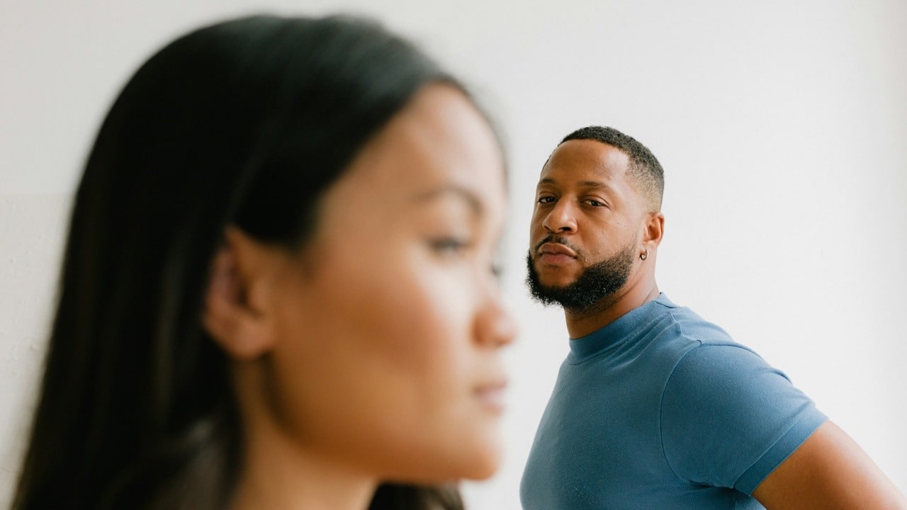 A man looking at her angry wife.