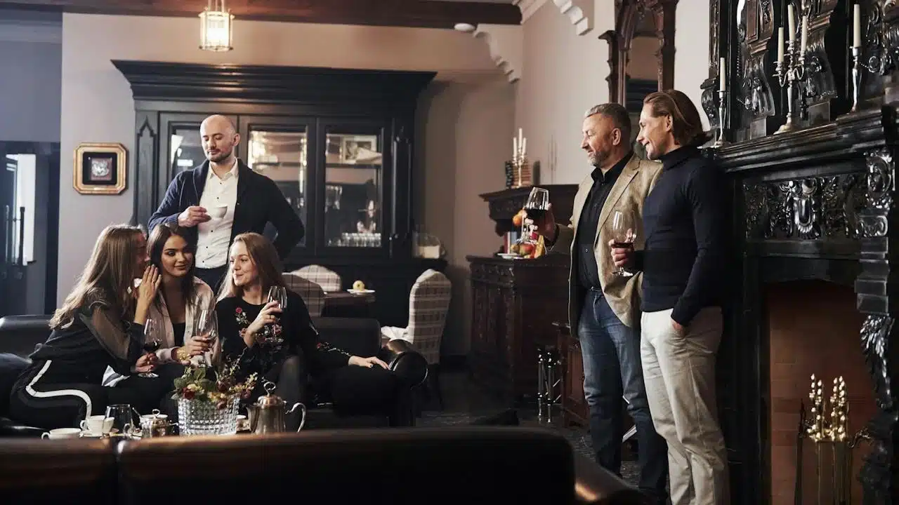 A group of people having wine while sitting together in a living room.