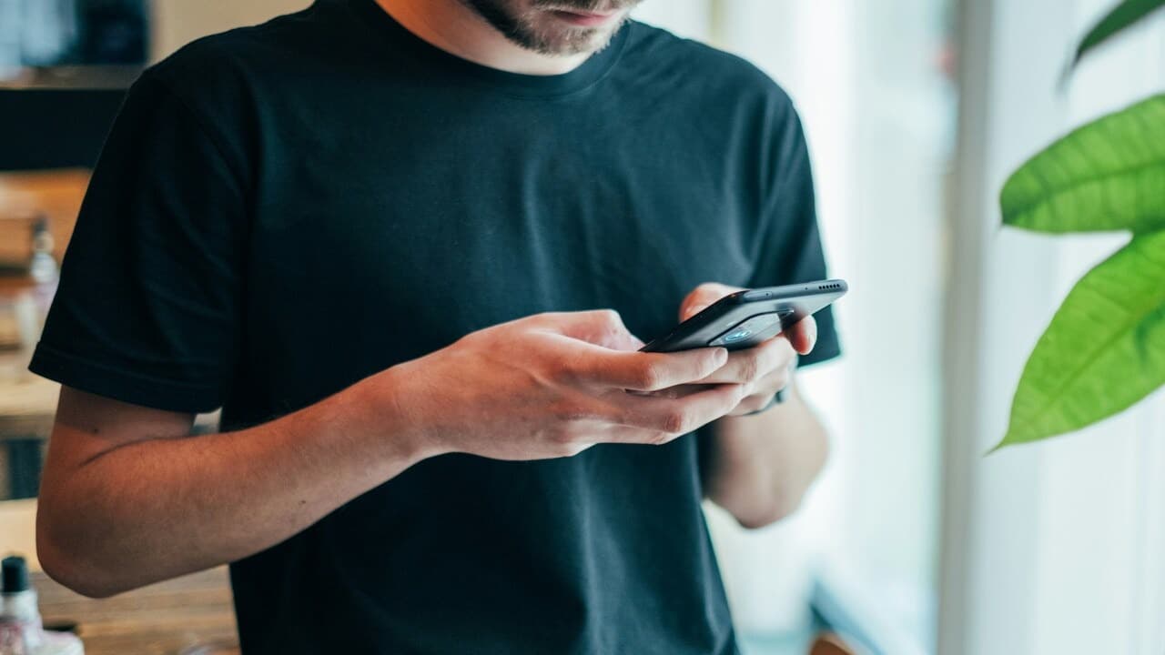 A man in a black shirt texting