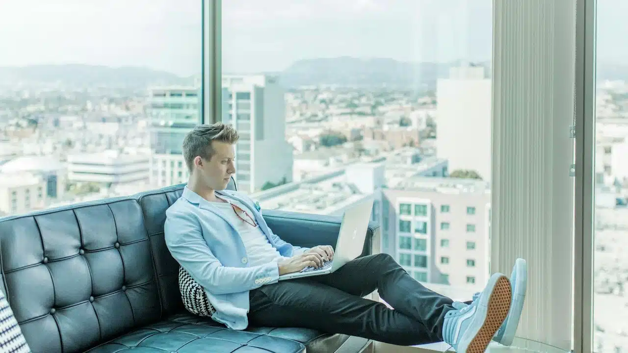 A man working on a laptop while sitting in his apartment.