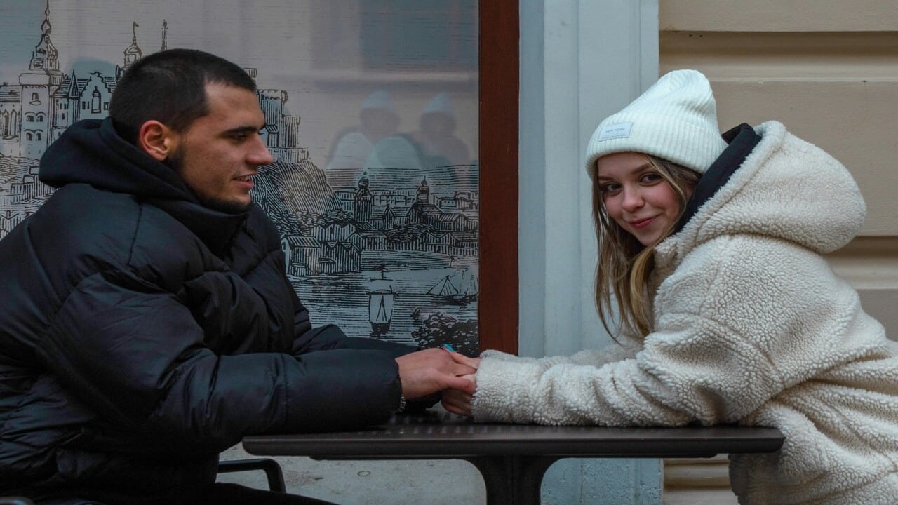 A man looking at a woman while holding hands