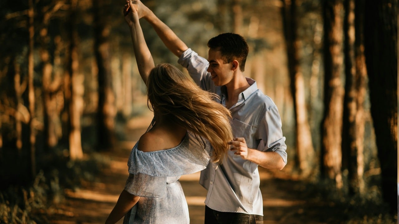 A couple dancing in a forest.