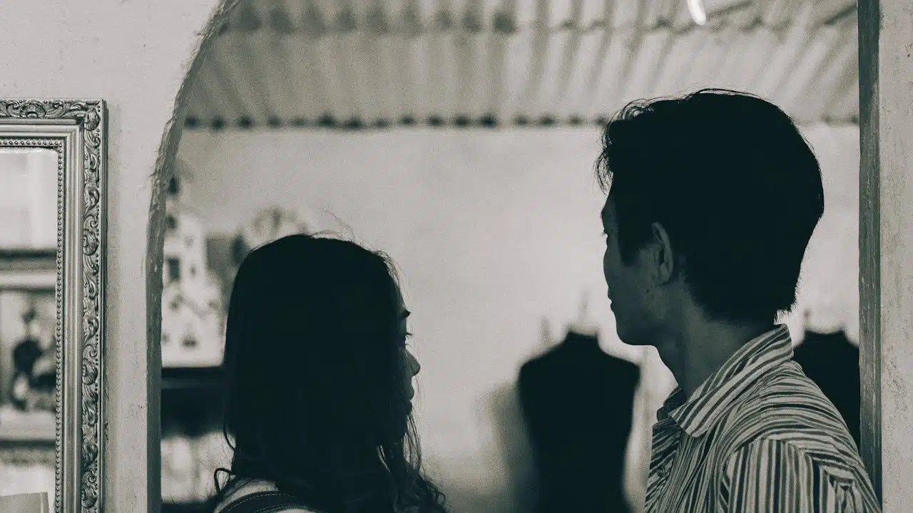A man and a woman standing in grayscale photography.