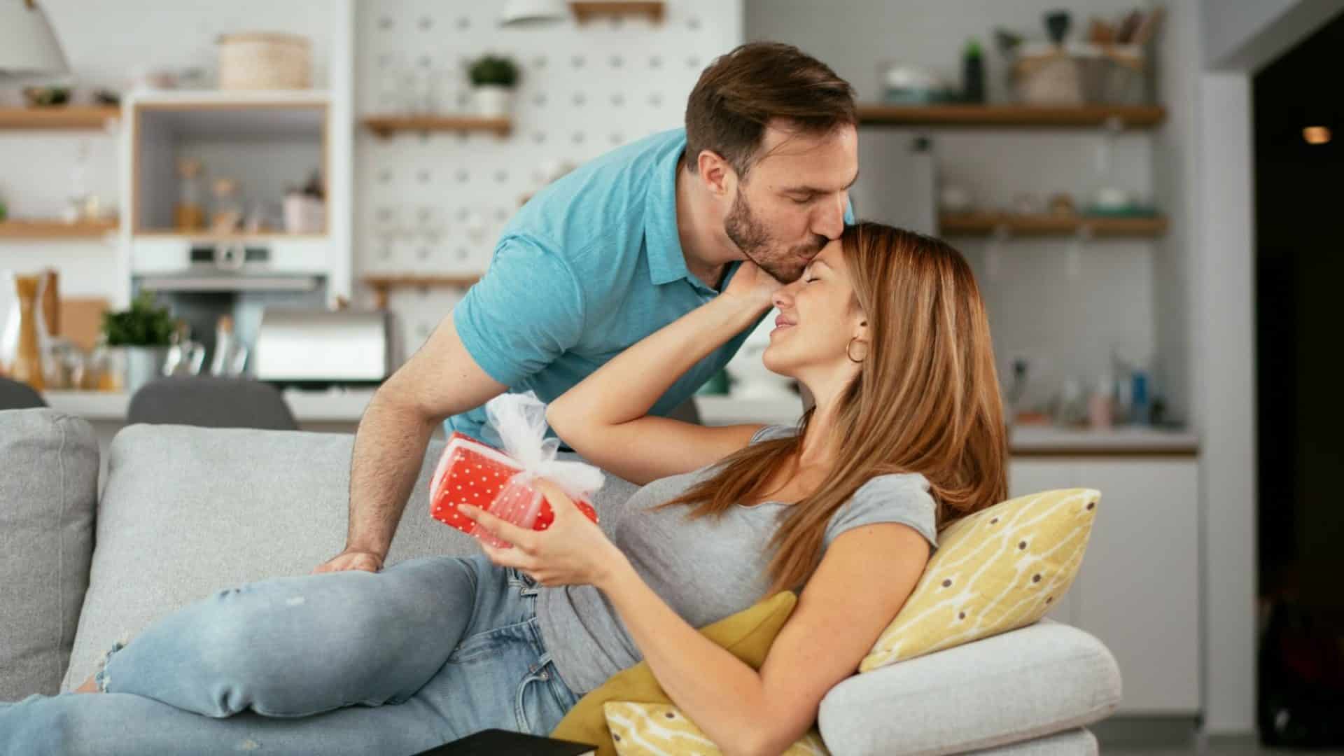A man kissing woman’s forehead