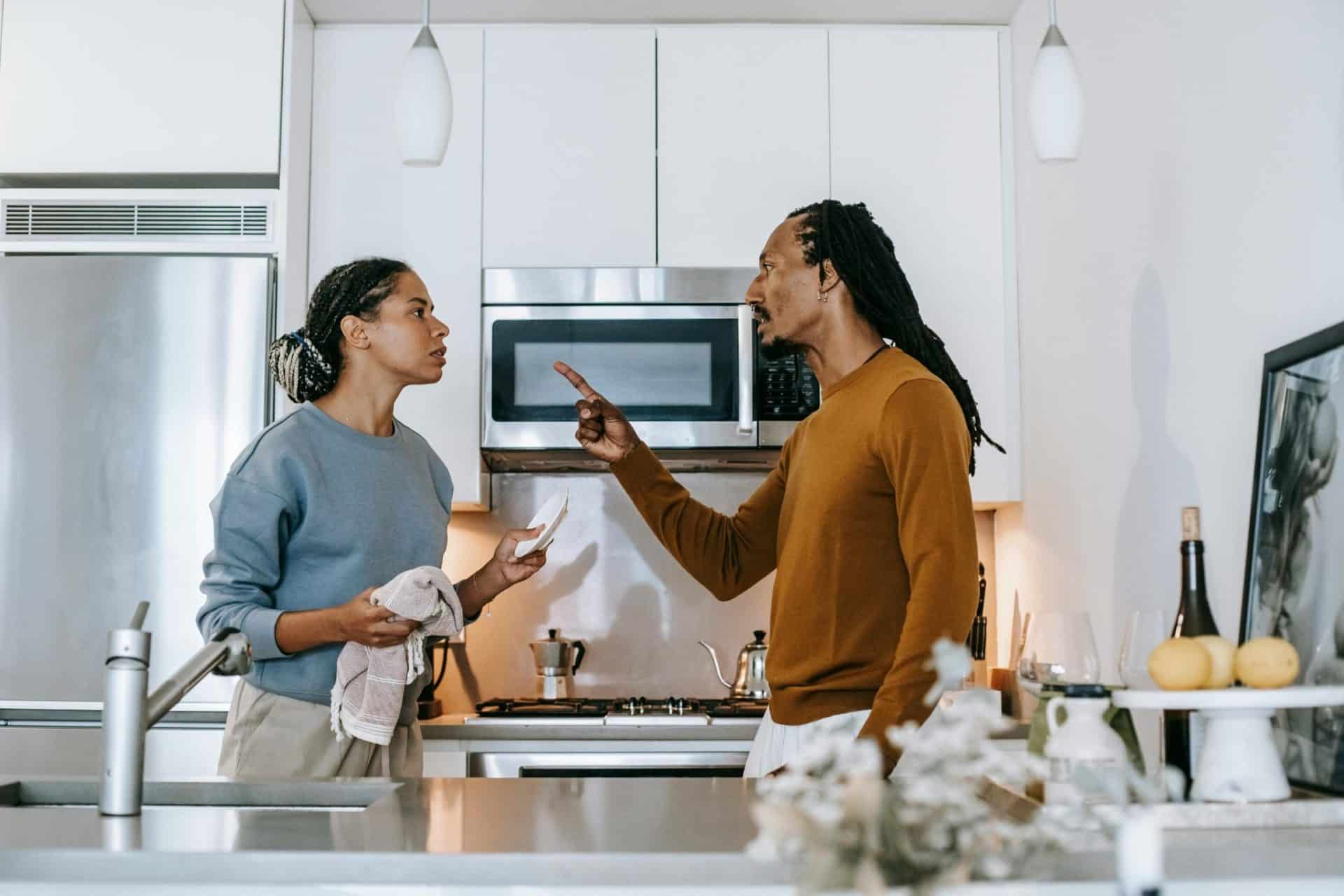 A couple arguing in the kitchen.
