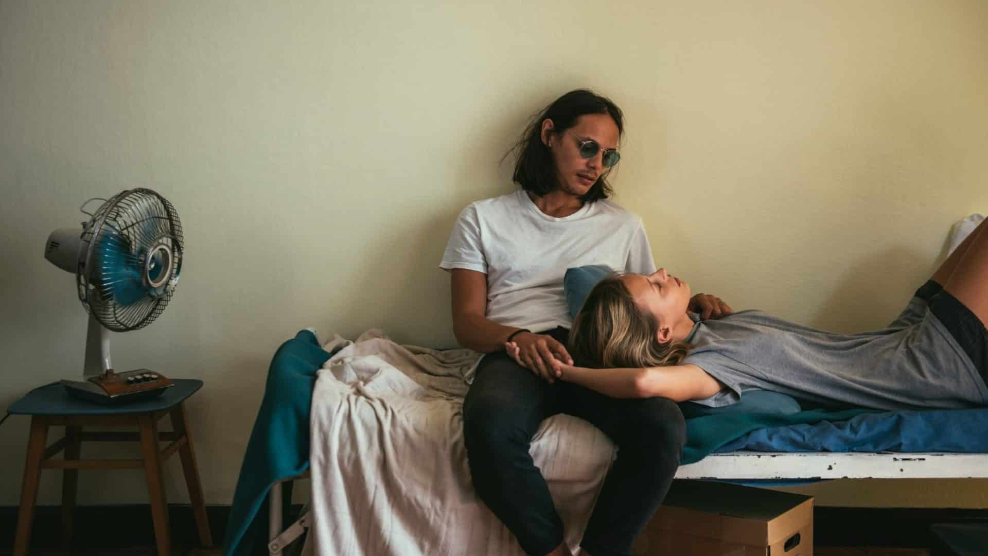 A woman resting her head on man’s lap