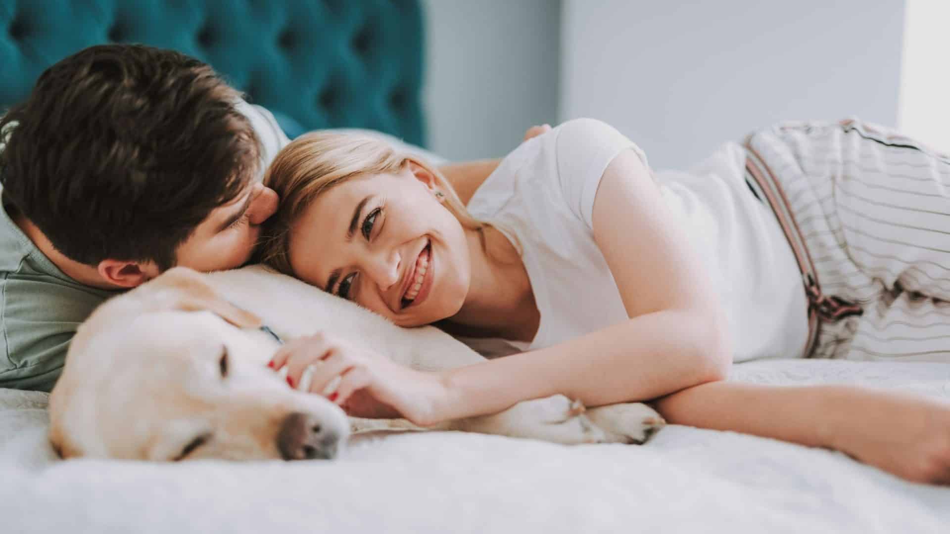 A man kissing woman’s head