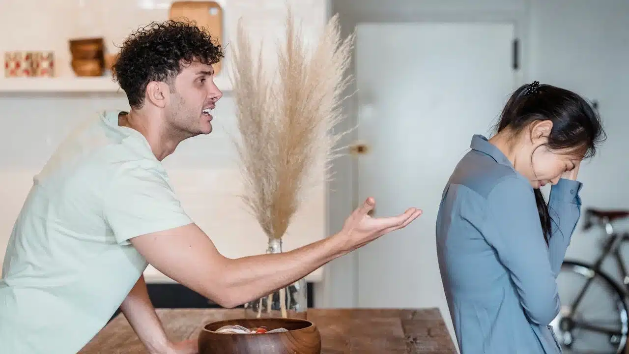 A couple standing with their faces turned from each other after a fight.