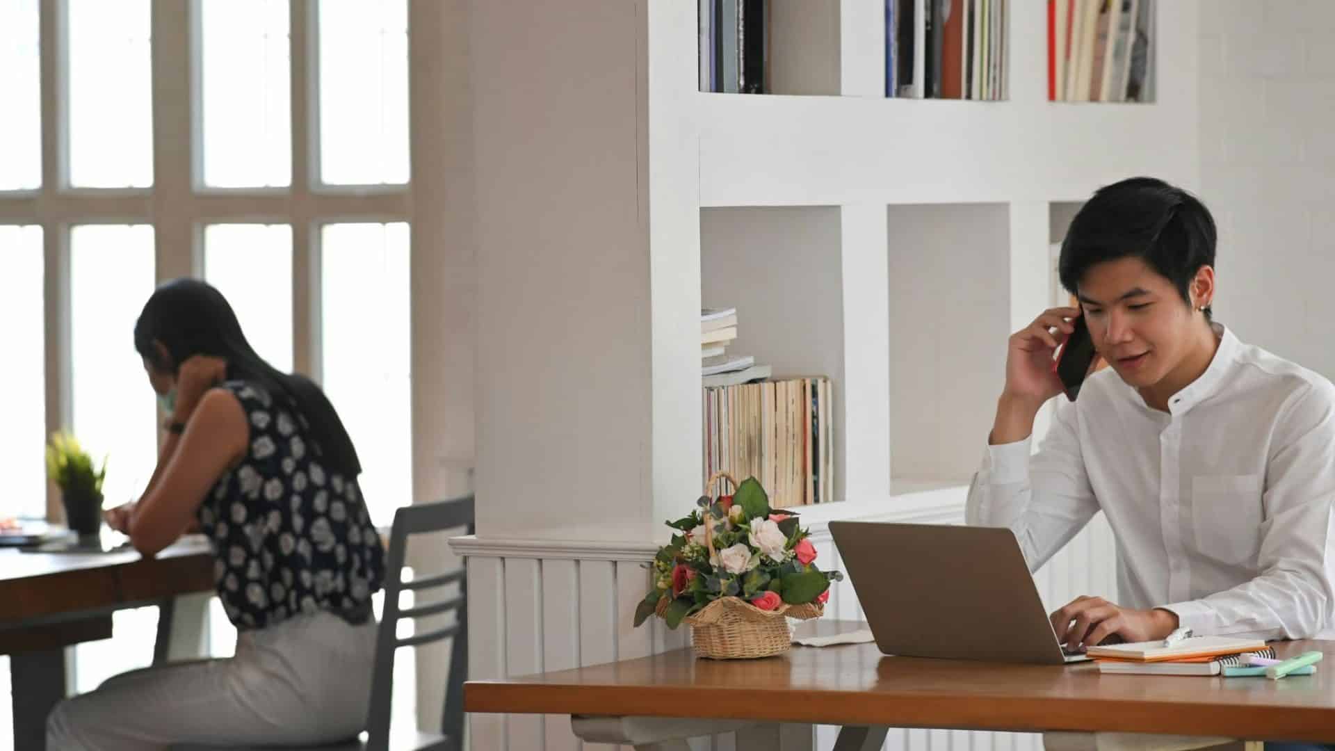 A man and woman busy with their own work