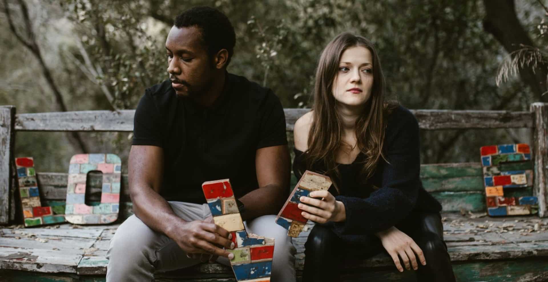 A couple sitting together but not interacting emotionally.