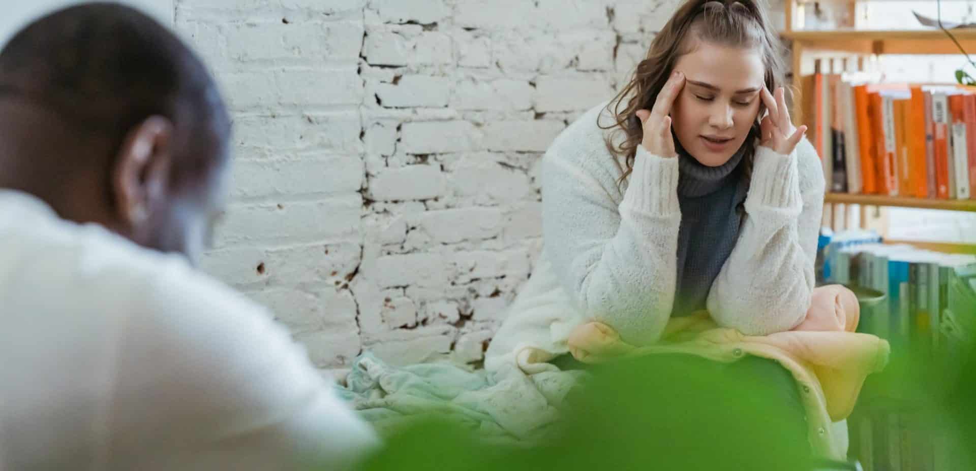 A woman appearing emotionally exhausted in conversation.