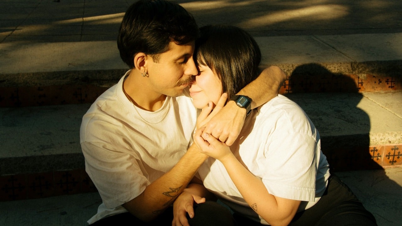 A couple embracing each other while they are sitting on stairs during daytime.