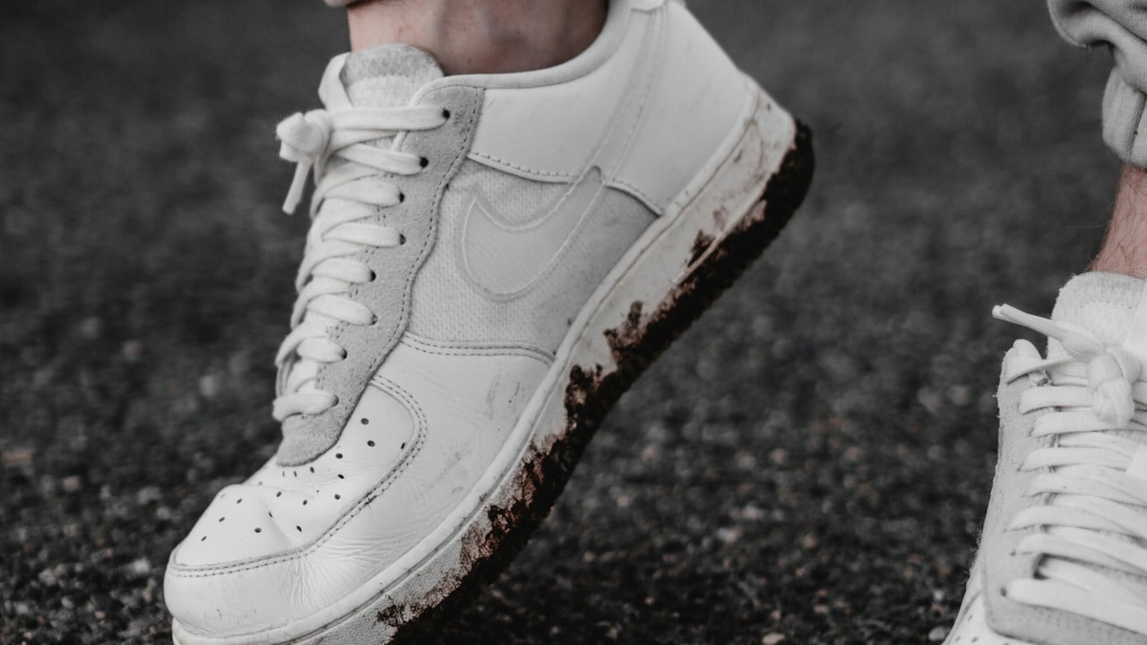 A man wearing dirty white sneakers.