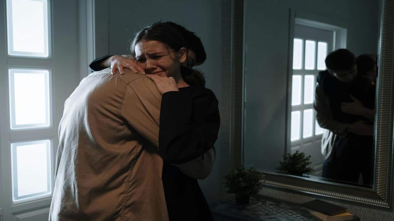A man embracing his crying girlfriend