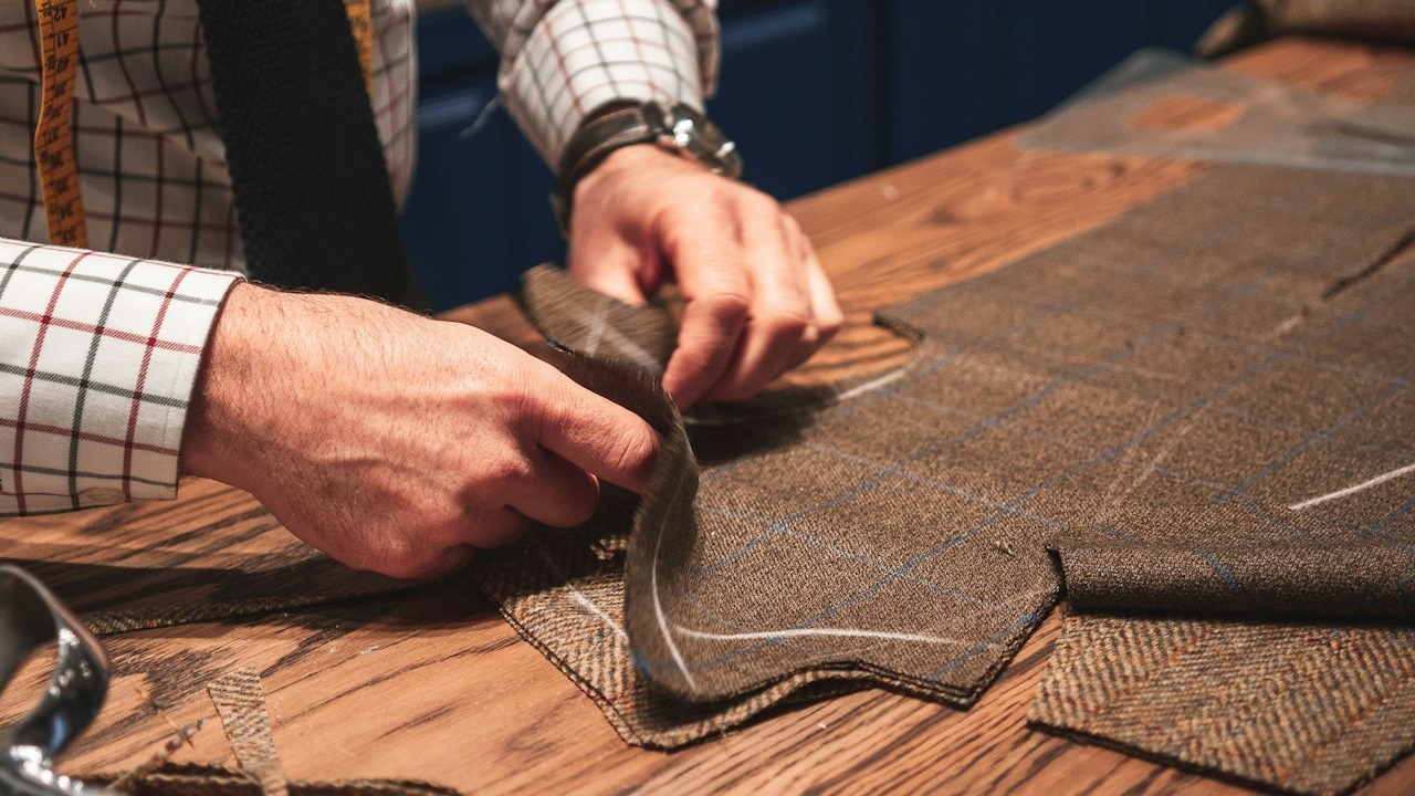 A tailor sewing some fabric.