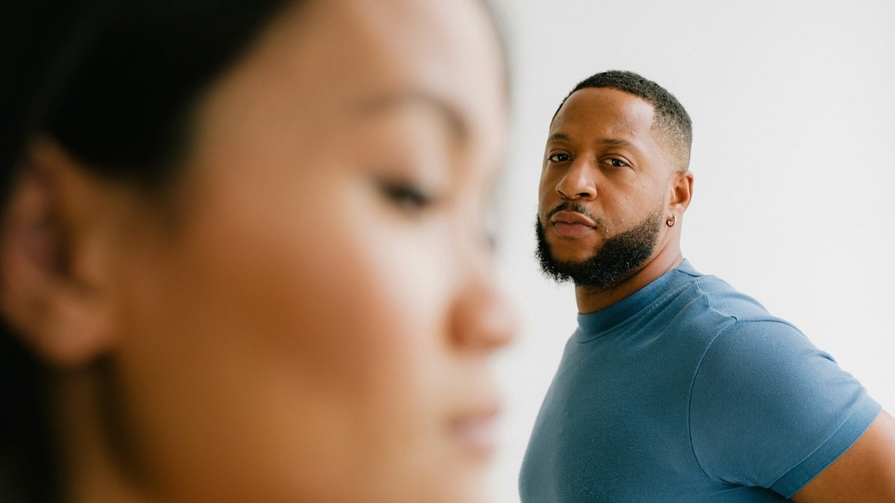 A bearded man looking at a woman intensely.