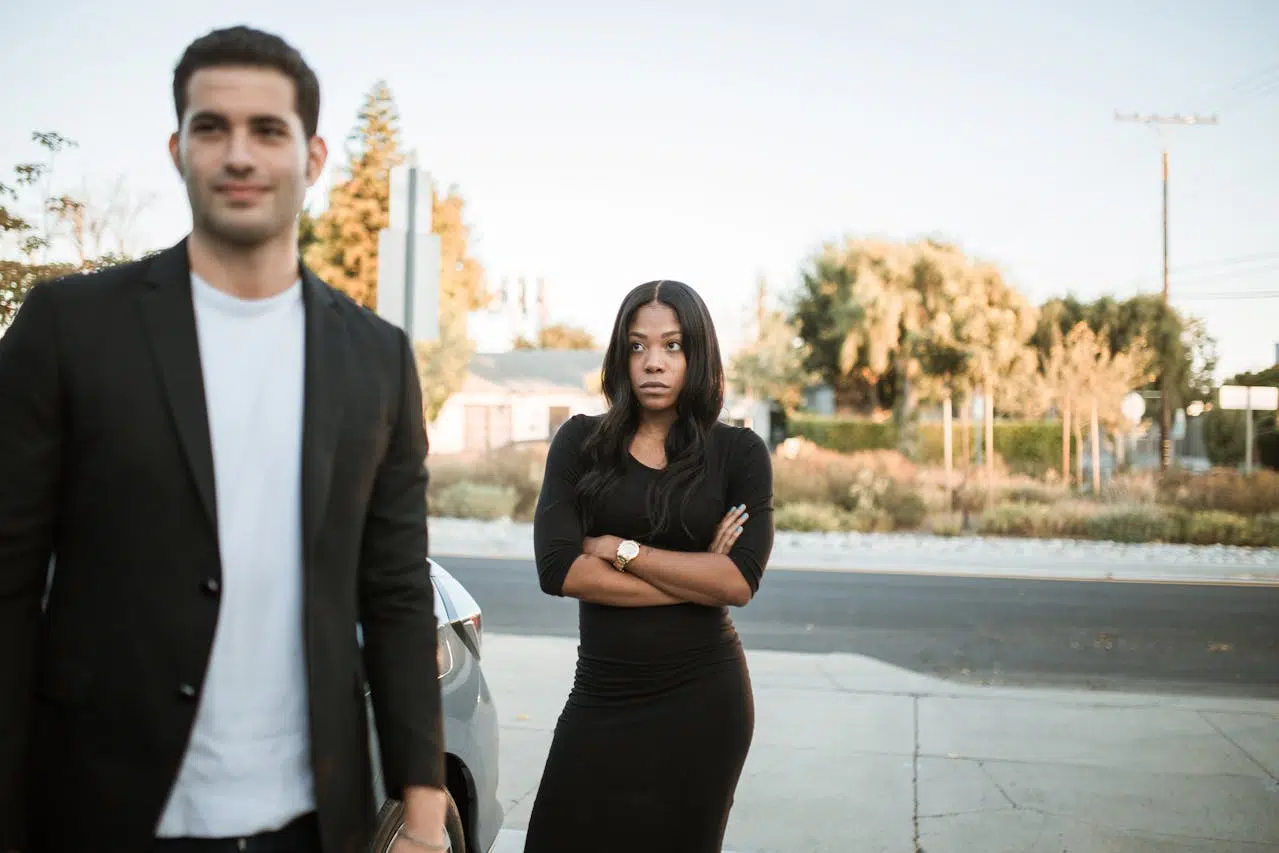A man is walking and a woman is looking at him moving away.