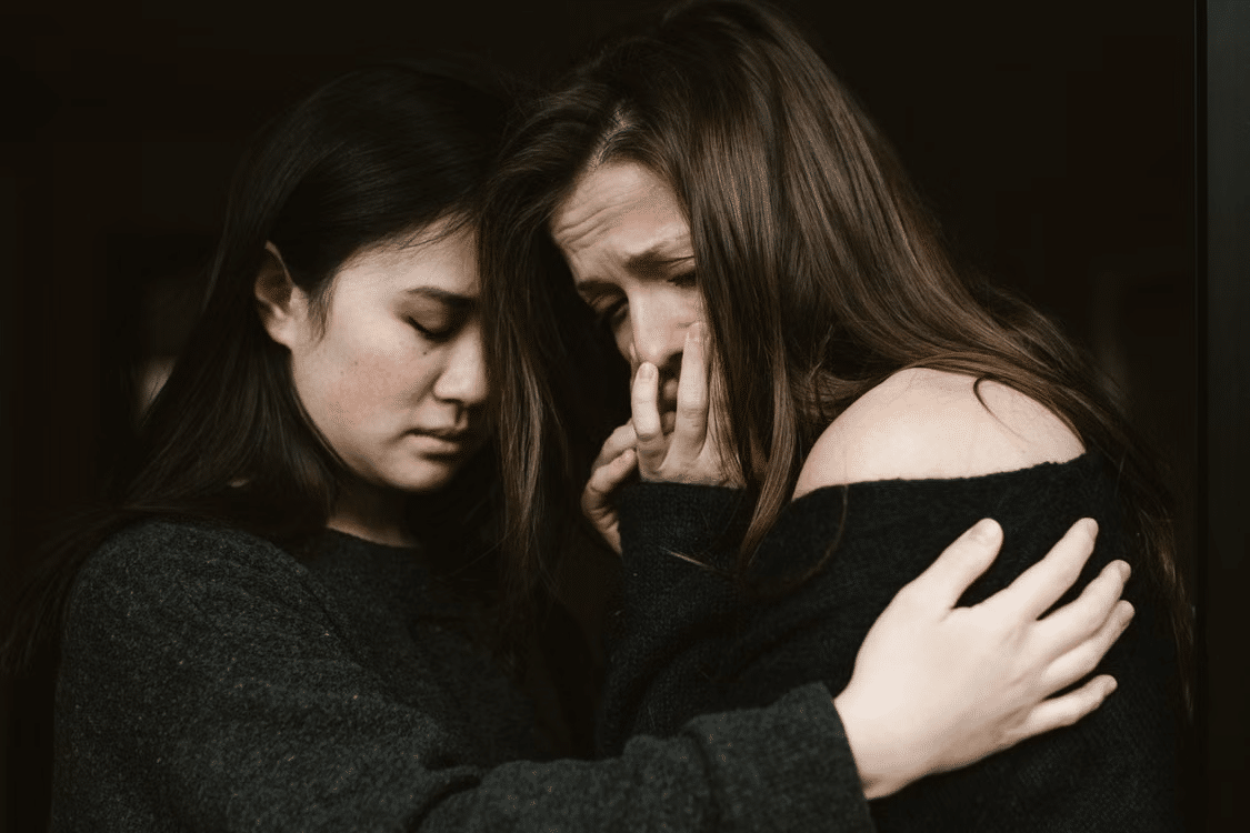 A woman giving comfort to a visibly emotional woman.