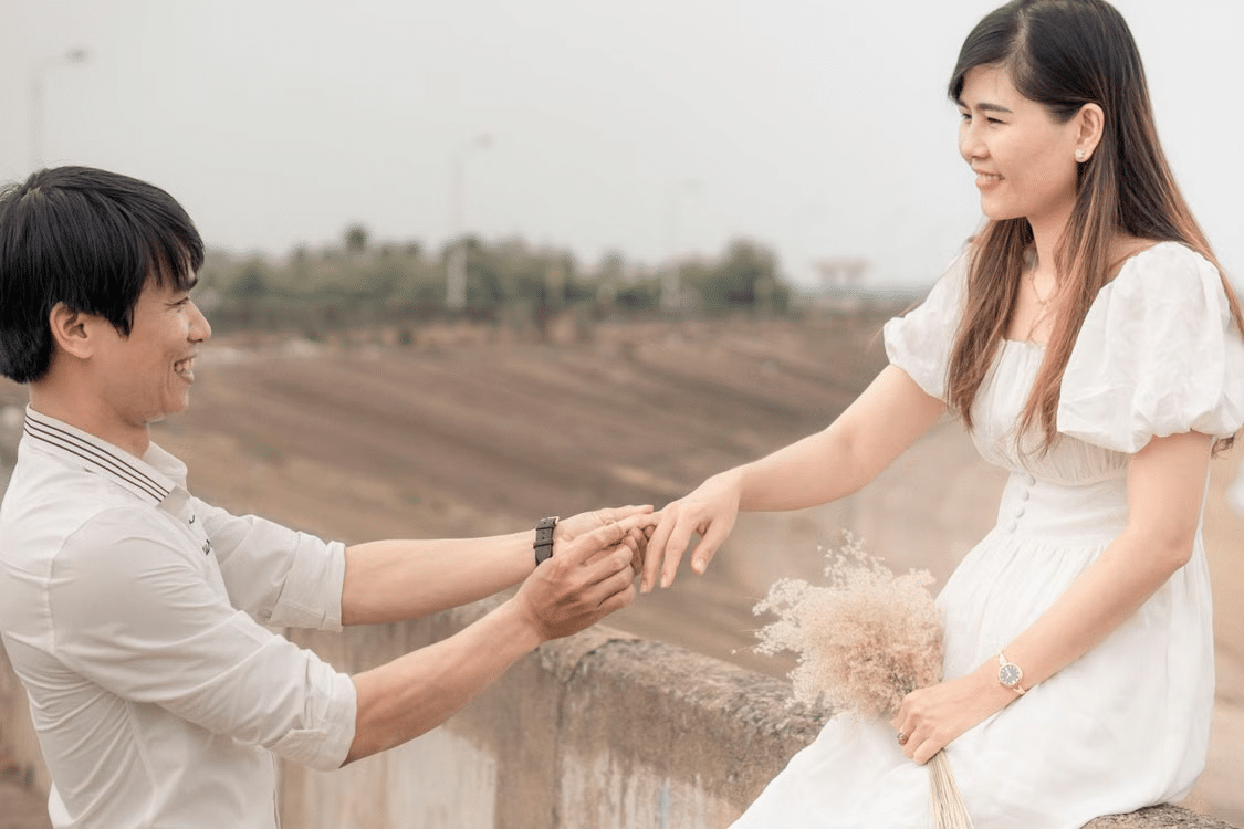 A photo of a man proposing a woman with a ring.