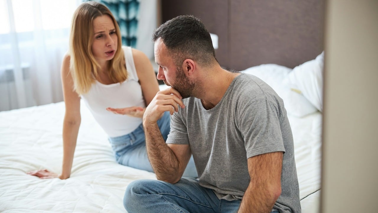 A couple discussing about their problems while they are sitting in their bedroom.