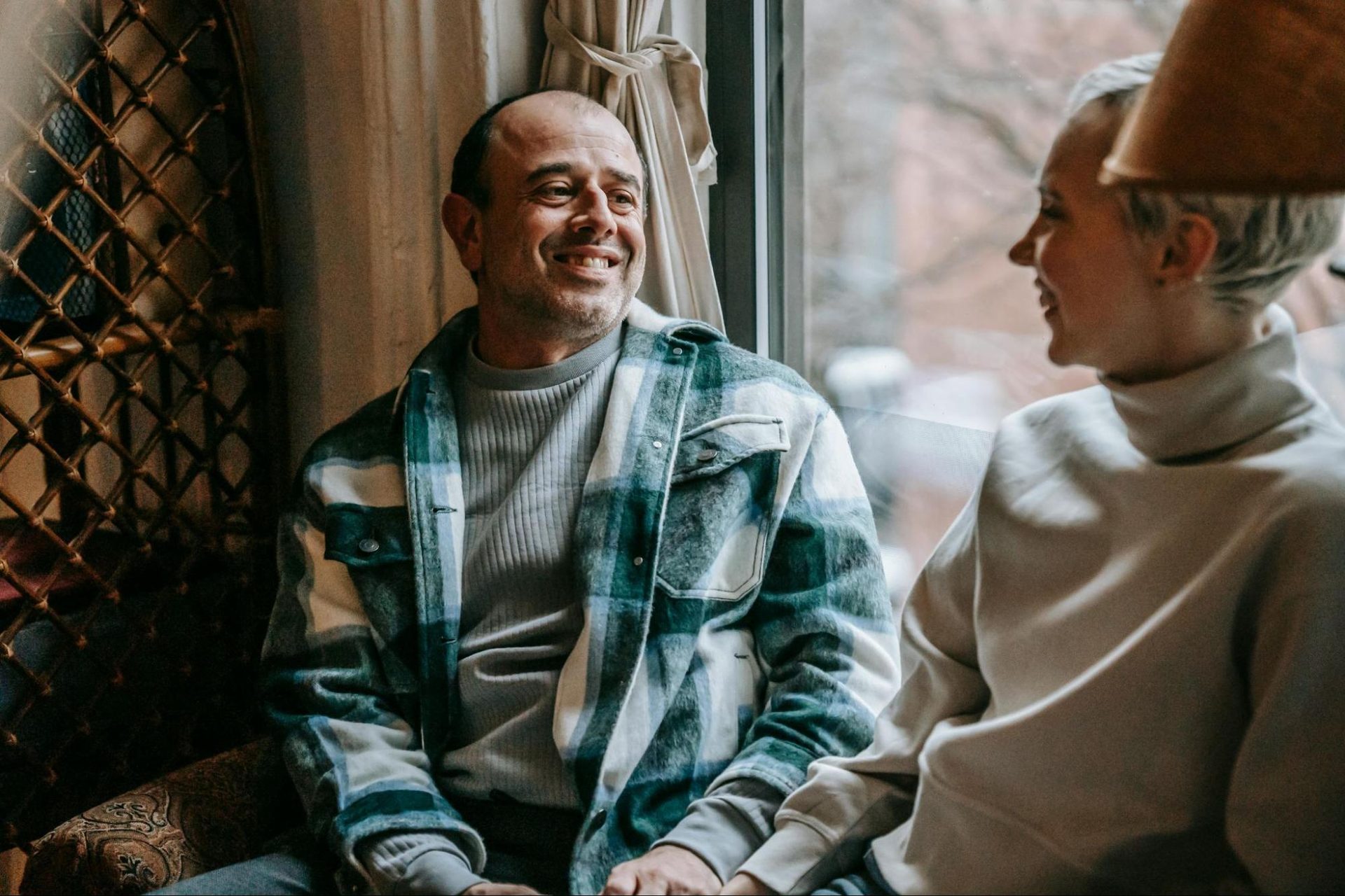 Man smiling while giving a woman a sincere compliment as she listens