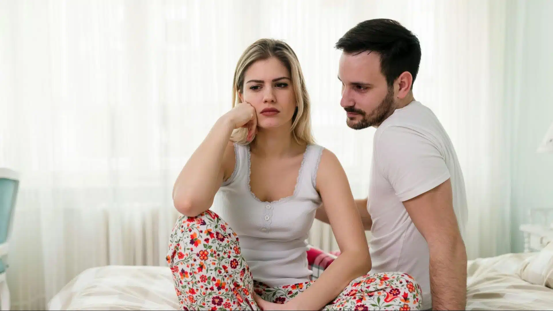A woman appears angry as a man approaches her with an apology.