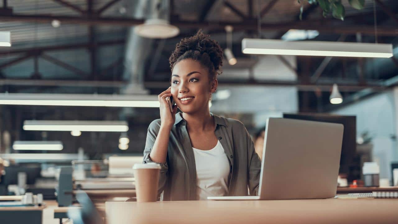 A woman exuding confidence as she smiles while talking on the phone.