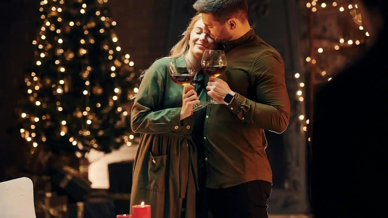 A couple holding wine glasses and celebrating.