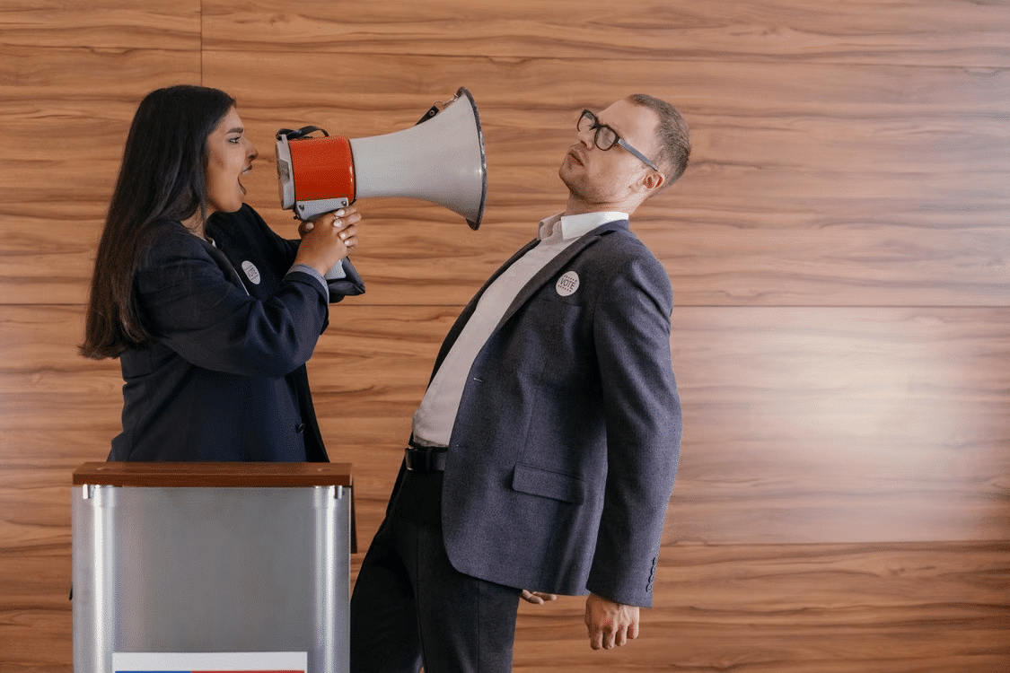 A woman openly shouting at a man through a speaker.