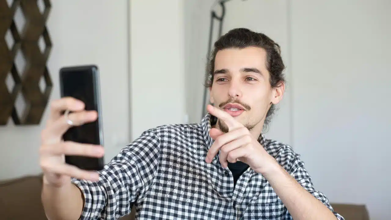 A man taking a selfie with a smartphone.