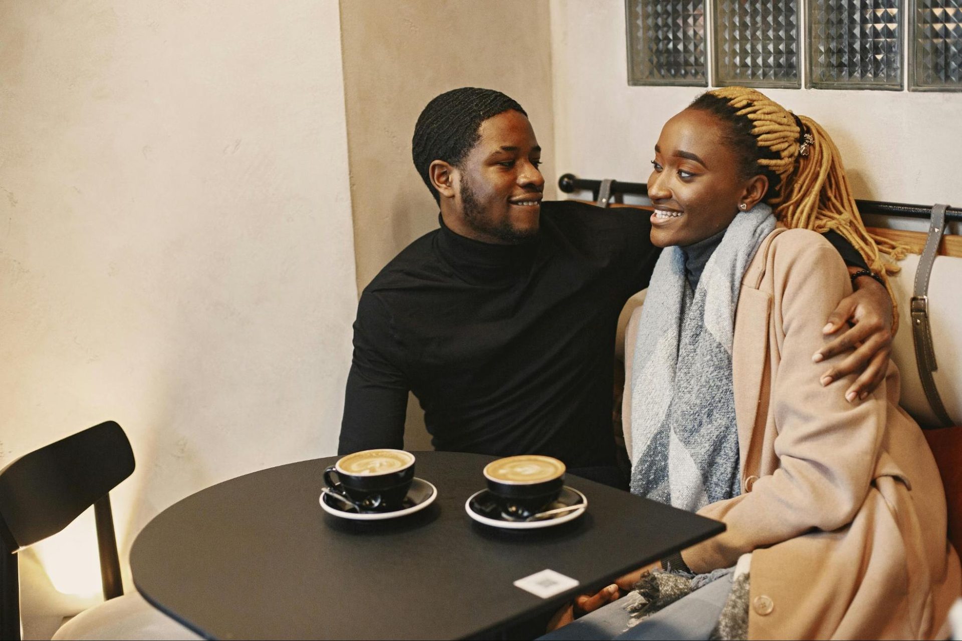 Man hugging a woman close while having coffee