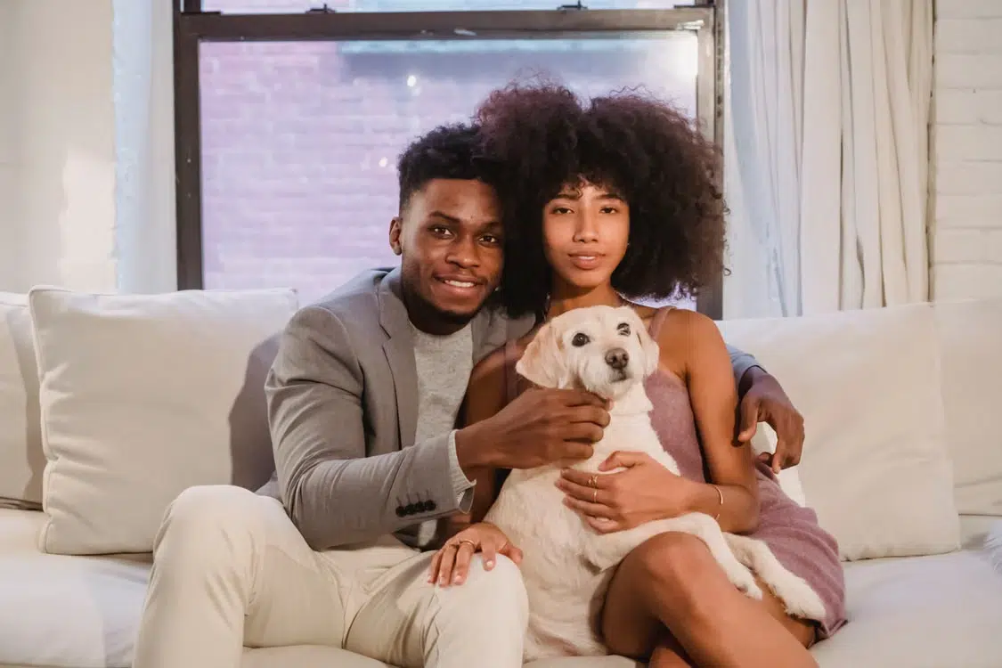 A black couple in love sitting on a couch.